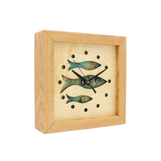 Fish at School, handcrafted cherry wooden Box Clock with fish design in maple over a aqua background. Angle view.