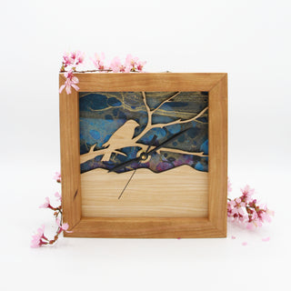 Bird on a Branch - Azure Sky, handcrafted Cherry Wooden Box Clock with Bird on a Branch design in maple over a blue swirled paper background. Pictured with Cherry Blossoms.