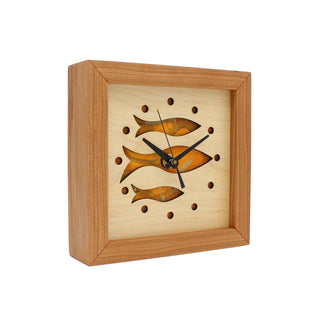 Fish at School, handcrafted cherry wooden Box Clock with fish design in maple over a orange background. Angle view.