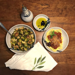 White and cobalt blue bowls collection on table, with pasta, Brussels sprouts, olive oil and herbs.
