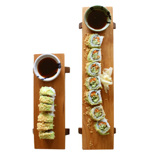 One short and one long cherry wood sushi boards and soy sauce bowls. Sushi & sauce pictured.